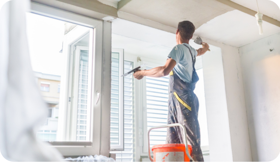 mężczyzna nakładający gładź w całym pomieszczeniu